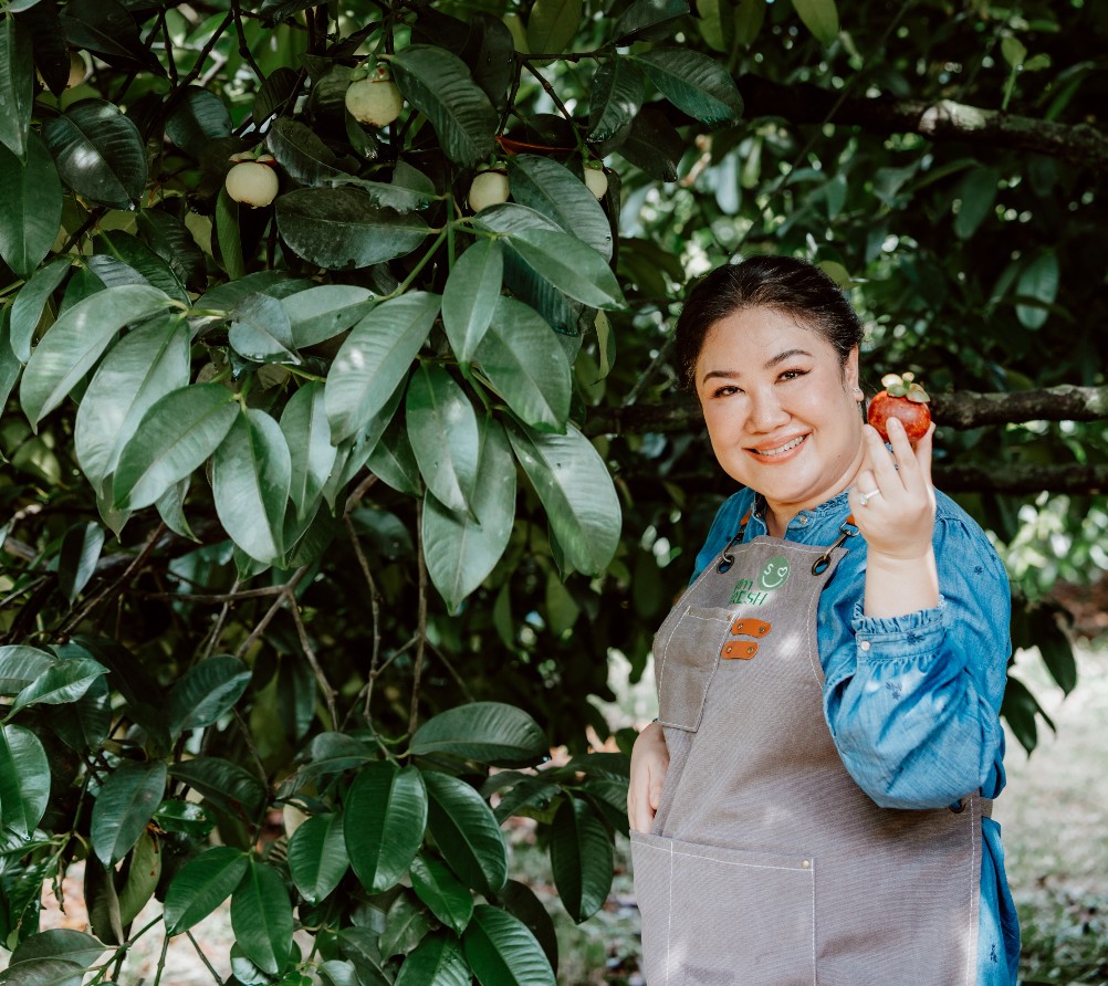 Siam Fresh team member holding ripe mangosteen